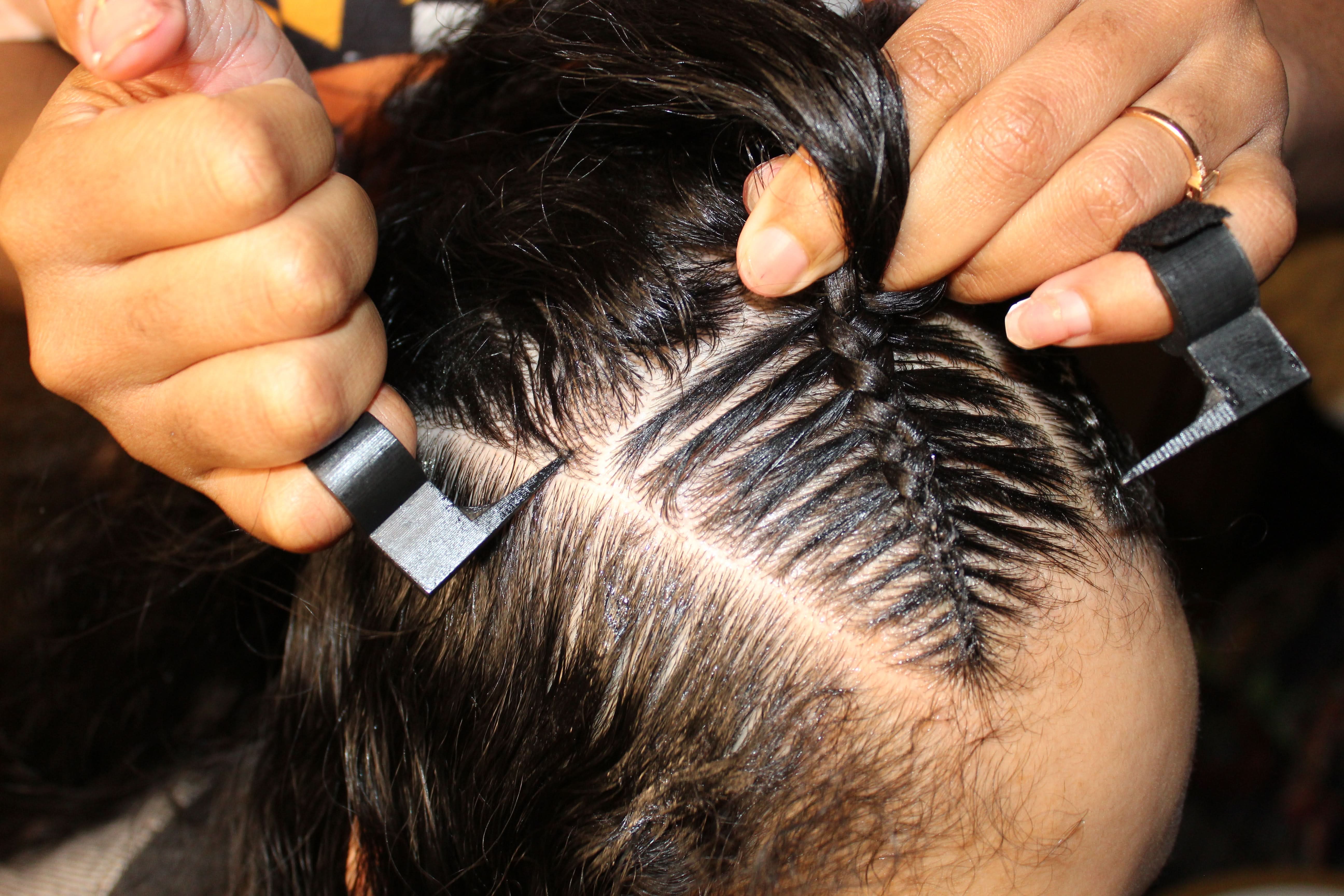 The Braid Aid- Adjustable Finger Parting Tool worn on fingers while parting hair for stitch braids, ensuring even and precise sections.